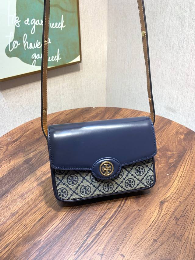 编号893 Tory Burch 汤丽柏琦 本款包袋采用编织提花与精致皮革交织制成 并饰以光滑的圆润包边 经典而实用 提花和光面皮革 皮革饰边 翻盖配磁力按扣