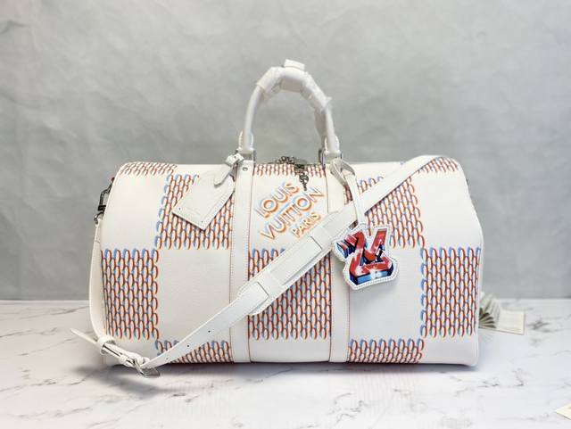 M 63 這款經典的keepall採用damier Spray元素點綴白色牛皮 展現全新的時尚街頭風格 設計以立體噴灑效果演繹路易威登傳統的棋盤格紋圖案 並飾以