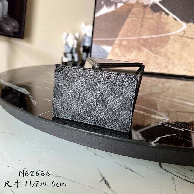 N62666 这款竖式组合卡片夹来自于时尚的 Damier Graphite 城市系列 设有两个夹层 可放置信用卡 交通卡或名片等卡片 可轻易放入上衣或裤装口袋