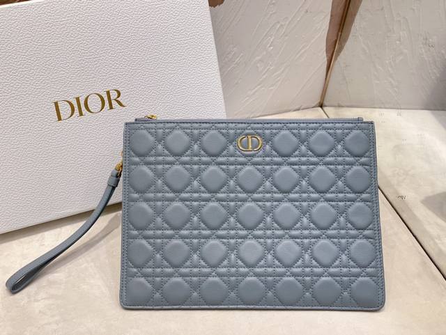 Dior Caro 日常手拿包是一款优雅实用的单品 采用云雾蓝色柔软牛皮革精心制作 饰以标志性的藤格纹缉面线 正面点缀以 Cd 标志 大号款式 可收纳各种日常用