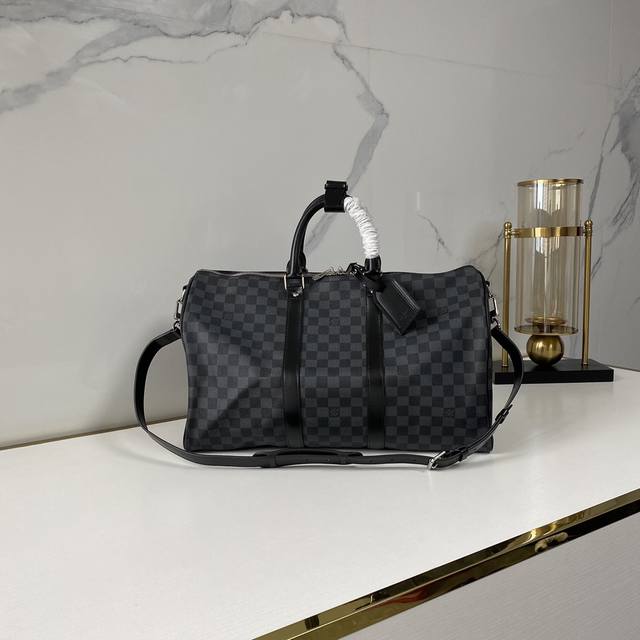 顶级原单 N41418黑格 这款经典的keepall 45手袋采用damier Graphite帆布制成，大小为手提行李尺寸。 特有浑圆的皮革手柄和可调整、可脱