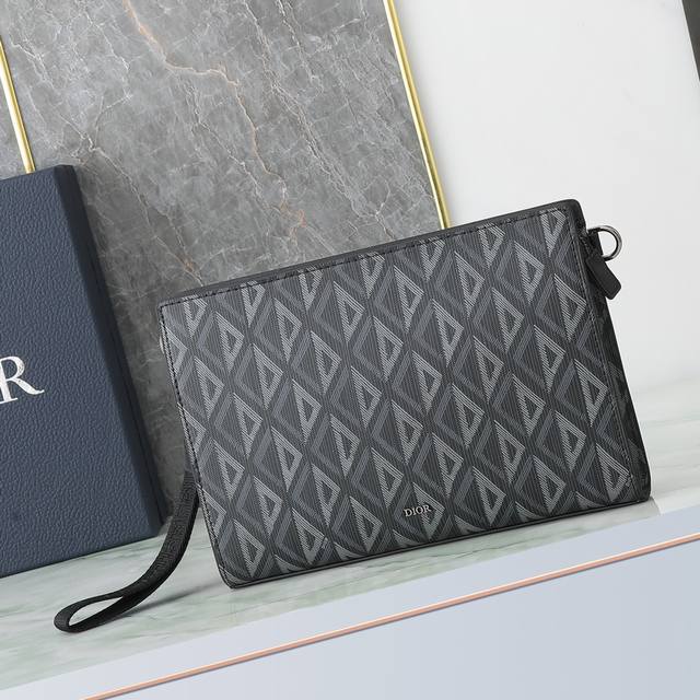 这款手拿包是 Dior 的主打单品。采和黑色 Oblique 印花面料精心制作，从 Dior 档案汲取灵感，正面饰以 Dior 标志提升格调。宽敞的拉链隔层适合