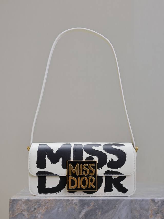 Miss Dior 翻盖手袋 米白色涂鸦 这款 Miss Dior 翻盖手袋于迪奥二零二四秋冬成衣系列发布秀上全新亮相，重新诠释 Dior 经典款式的现代优雅气