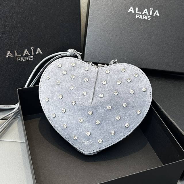 磨砂钻石 Alaia Coeur Bag 爱心手袋系列，立体爱心设计辨识度超高，拉链袋配有可调式的肩带，非常适合携带必需品，造型简洁，包包印有精致的 Logo