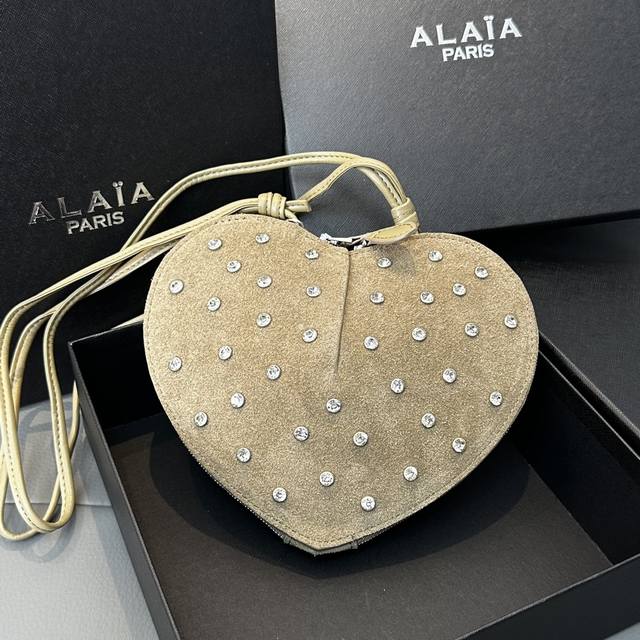 磨砂钻石 Alaia Coeur Bag 爱心手袋系列，立体爱心设计辨识度超高，拉链袋配有可调式的肩带，非常适合携带必需品，造型简洁，包包印有精致的 Logo