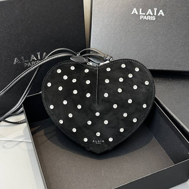 磨砂钻石 Alaia Coeur Bag 爱心手袋系列，立体爱心设计辨识度超高，拉链袋配有可调式的肩带，非常适合携带必需品，造型简洁，包包印有精致的 Logo