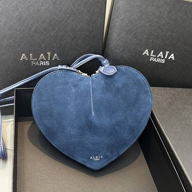 磨砂 Alaia Coeur Bag 爱心手袋系列，立体爱心设计辨识度超高，拉链袋配有可调式的肩带，非常适合携带必需品，造型简洁，包包印有精致的 Logo 银色