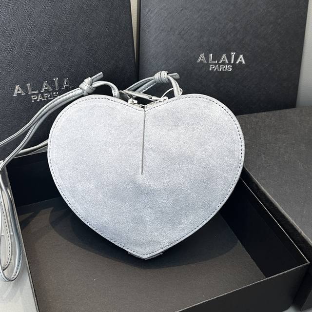 磨砂 Alaia Coeur Bag 爱心手袋系列，立体爱心设计辨识度超高，拉链袋配有可调式的肩带，非常适合携带必需品，造型简洁，包包印有精致的 Logo 银色