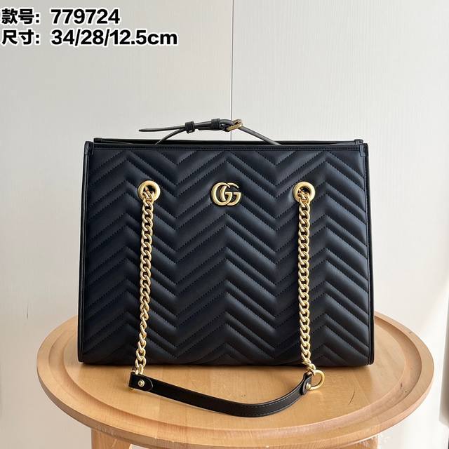 型号：779724牛皮 尺寸：34X28X12.5Cm Gg Marmont系列在2024年春夏系列中继续大放异彩。这款托特包采用黑色绗缝皮革匠心制作，搭配隽永