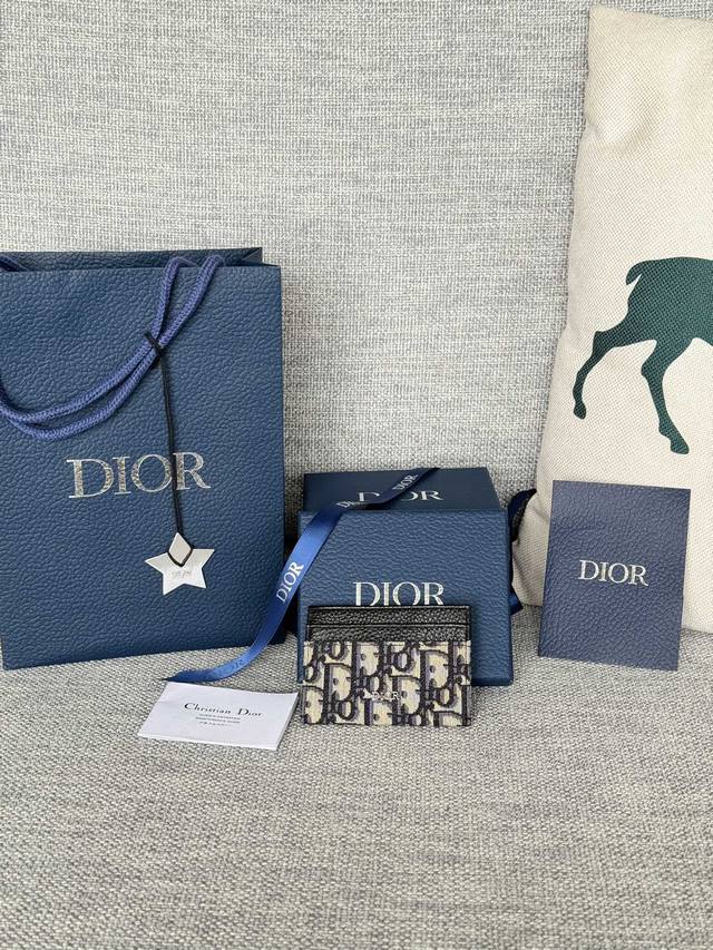 细长而小巧的 Dior Oblique 卡夹便于携带卡片和现金。时尚的米色和黑色 Dior Oblique 图案提花材质，制作 流线型结构，轻松装入各式口袋。