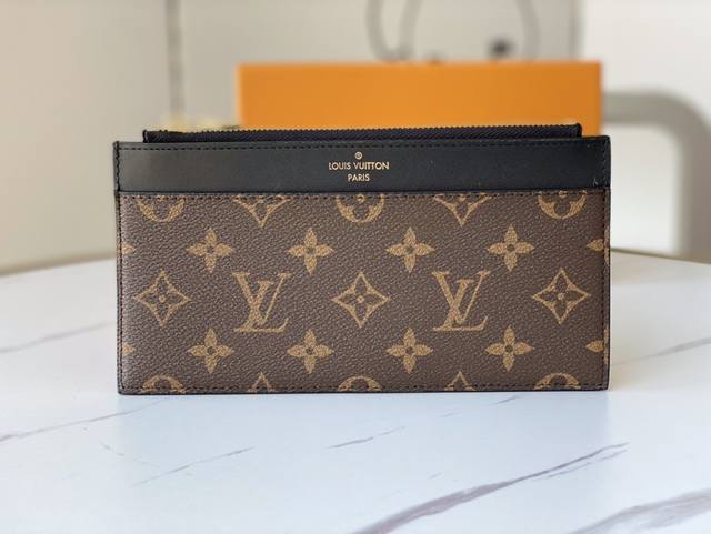 M80390 Slim Purse 手拿包 采用 Monogram 帆布和丝滑牛皮实现简约构型，点缀标识压纹，设有拉链主隔层、外贴袋、外隔层和卡位，亦可置于其他